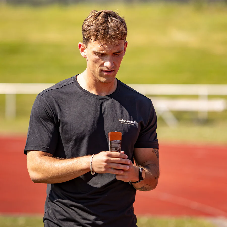 Mand holdr energi gel på en løbebane